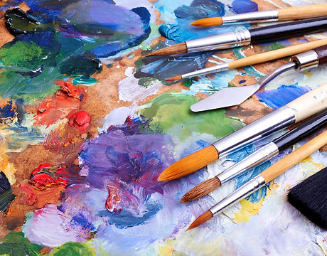 artists brushes and oil paints on wooden