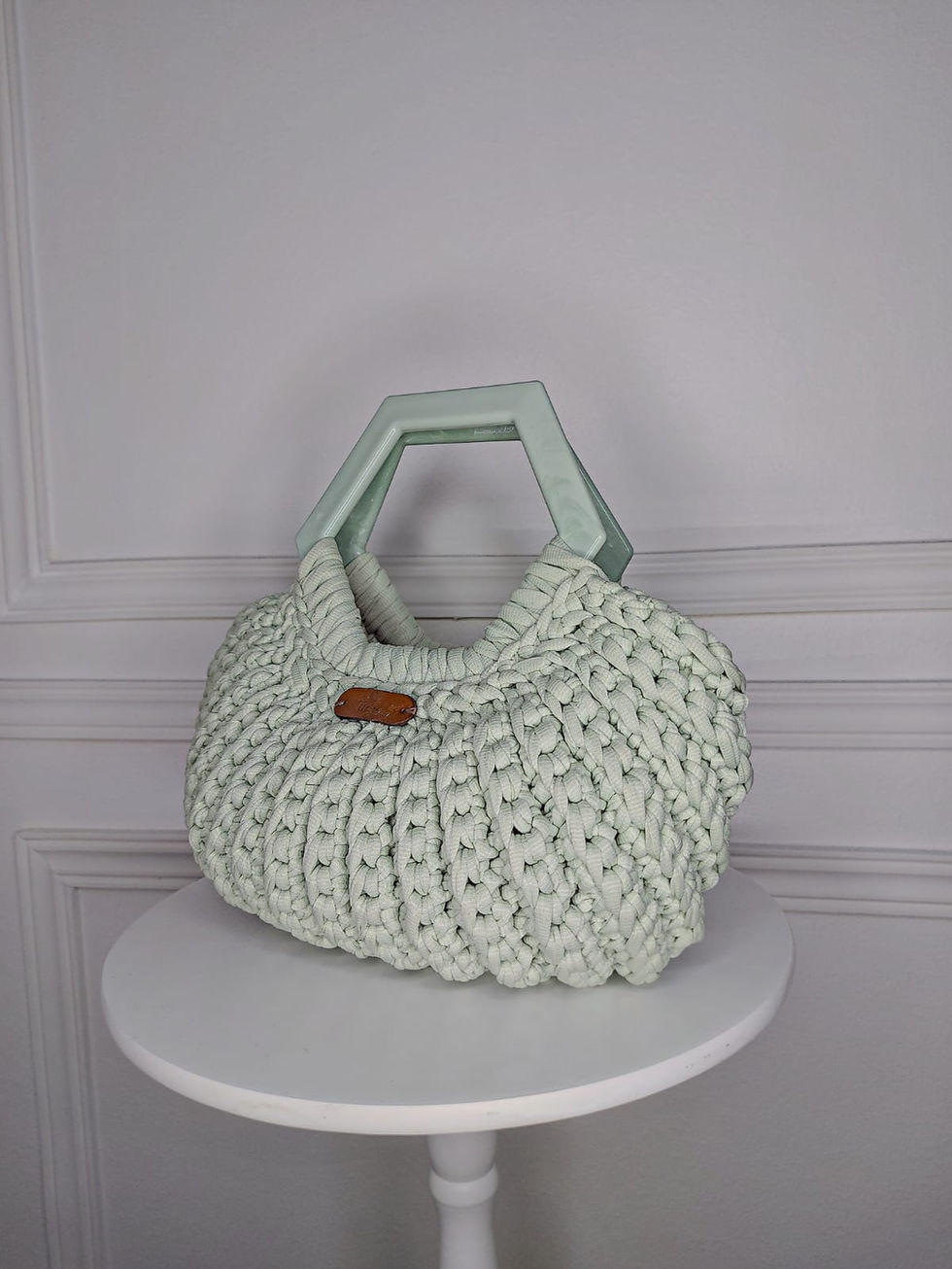 Bolsa em crochê com fio de malha na cor verde claro, alça em resina na cor verde claro.