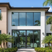 A 2 story modern home with white stucco, cypress nickel gap siding and floor to ceiling windows