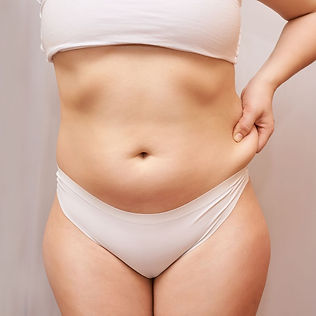 Women pinching loose belly skin