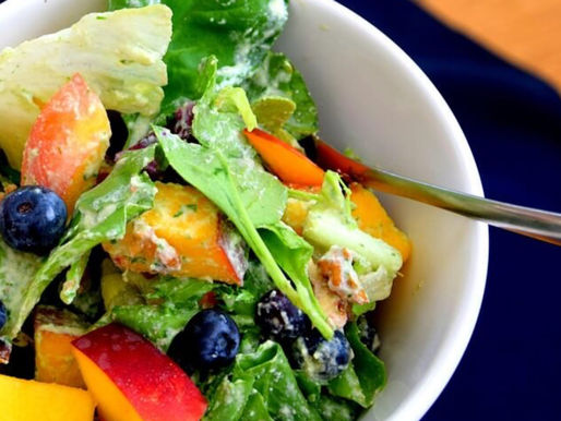 Groene salade met mango, blauwe bessen en een gezonde dressing in een kom