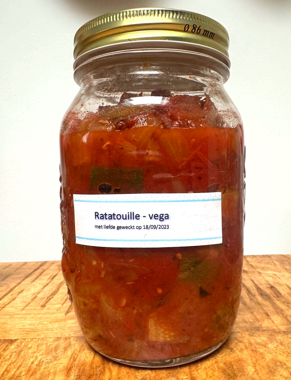 Pot met rode ratatouille, label met tekst "Ratatouille - vega, met liefde geweckt op 18/09/2023". Staat op houten oppervlak.