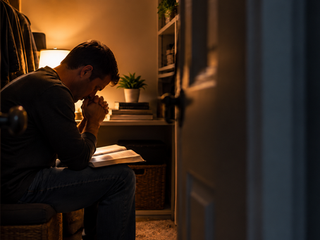 Man praying with an open Bible while spending quiet time with God in his secret place