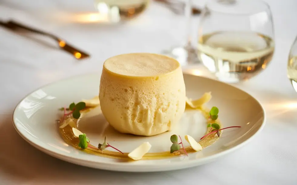 Vignette photo-réaliste d’un soufflé glacé au marc de Champagne gastronomique, dressé comme dessert signature dans un restaurant chic, illustrant Fin d’année comment le Soufflé Glacé au Marc de Champagne valorise votre offre dessert.