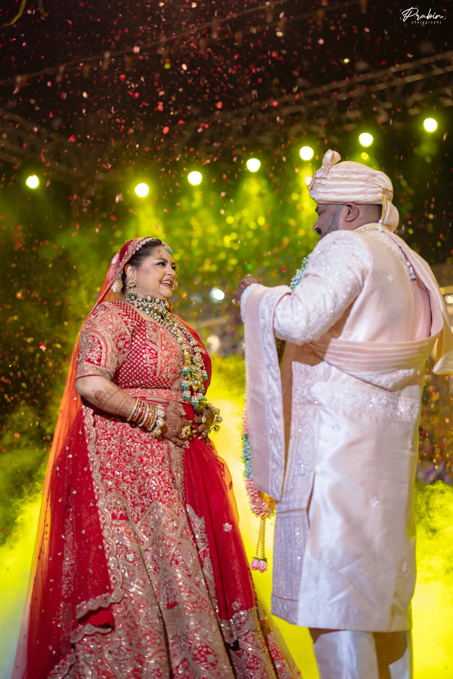 Bride smiling at the groom beneath warm lights