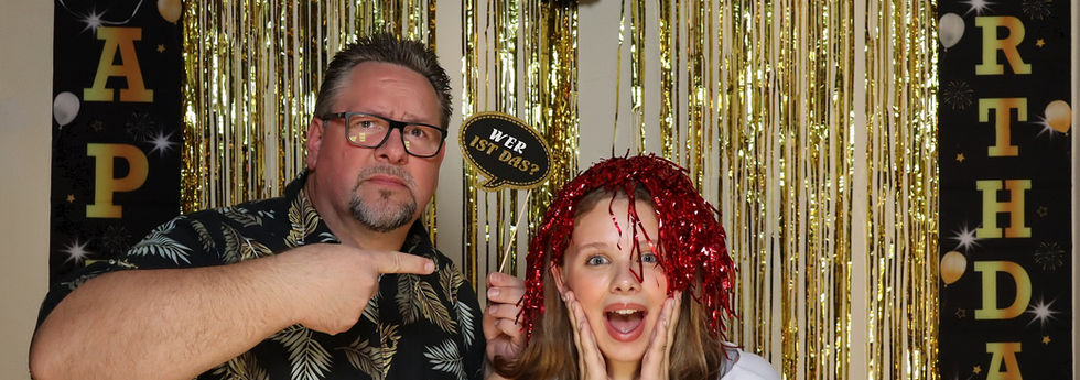 Zwei Gäste posieren gemeinsam mit Requisiten vor der Fotobox