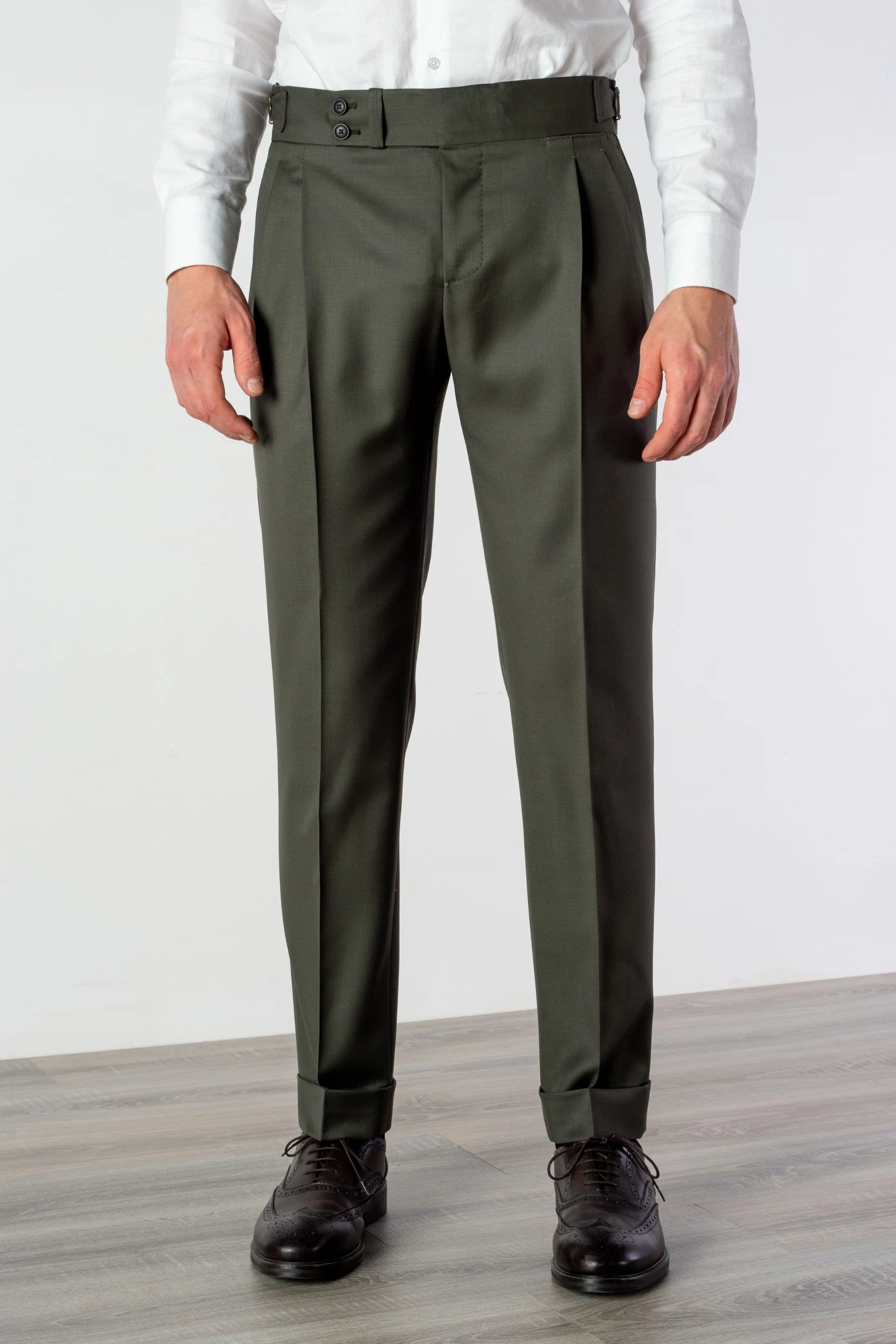 Premium tailored Amalfi Green wool trousers with reverse pleats, slanted pockets, and custom-fit adjustable side belts.