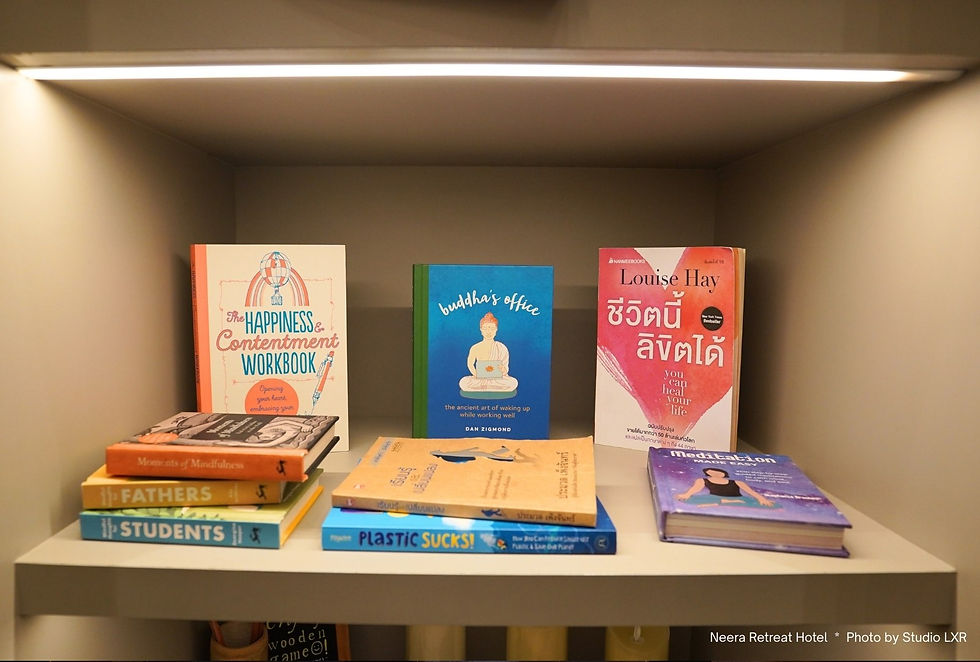Books on a shelf, featuring titles on mindfulness and happiness. Bright covers, including blue, pink, and orange. Calm, organized setting.