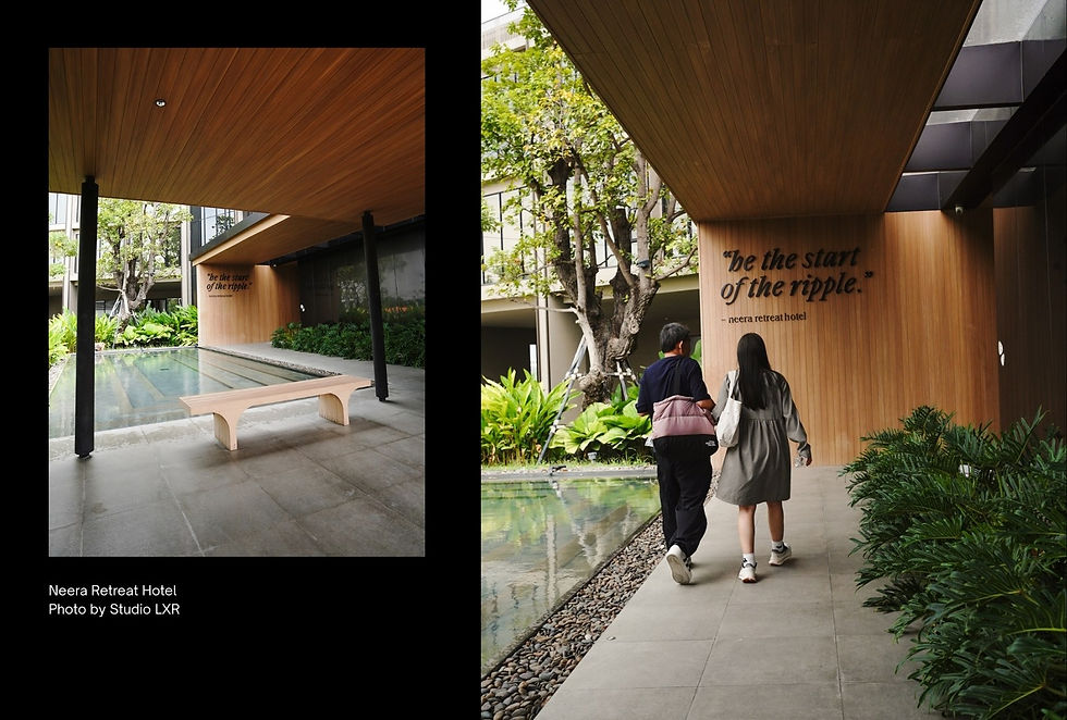 People walk by a pool with greenery at Neera Retreat Hotel. A wall reads "be the start of the ripple." Calm, natural setting.