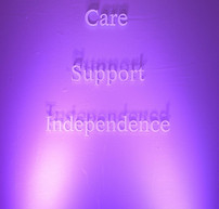 Illuminated backdrop with showing the words Care • Support • Independence stacked. Colour 
