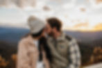 Couple snuggling on some rocks in a creek