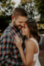 Couple snuggling close with guy kissing girlfriends head