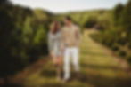 Couple walking and laughing through christmas tree farm