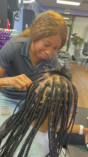 scalp parted with knotless braids and blue sleeveless top