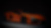 side view of orange lamborghini in the dark_