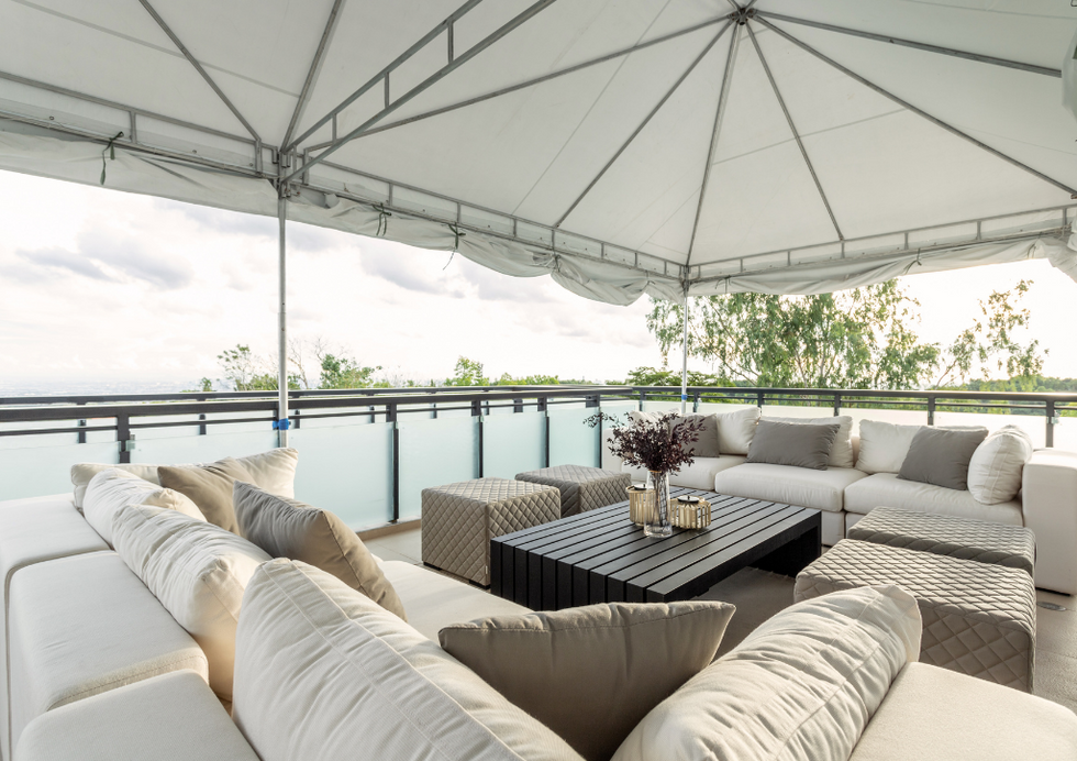 White outdoor seating area with canopy and water view.
