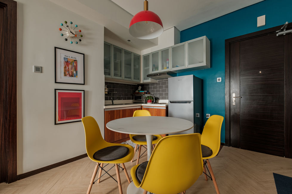 Modern kitchen with yellow chairs and colorful decor.