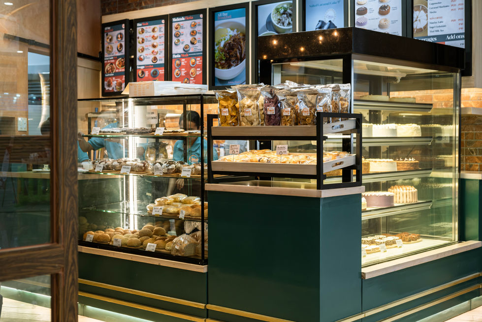 Small bakery counter with pastries and menu boards.