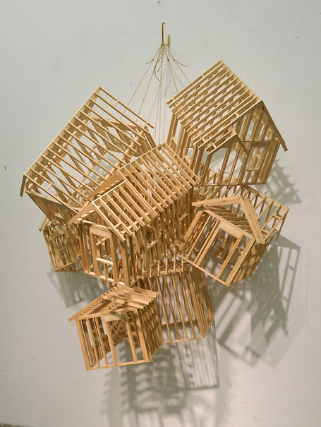 models of small houses hung from string against a wall