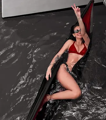 A woman is in a hammock on the water during an excursion on a trimaran