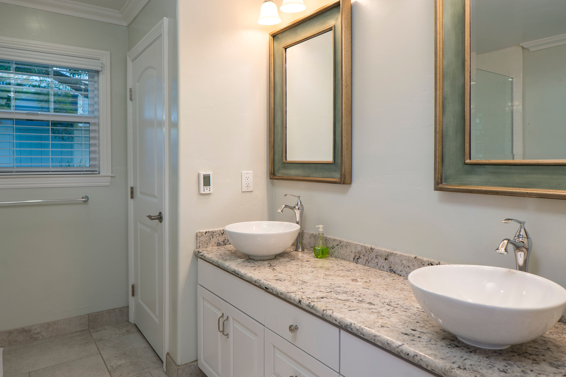 A completed home remodel in the bathroom, white cabinets, and bowl sinks