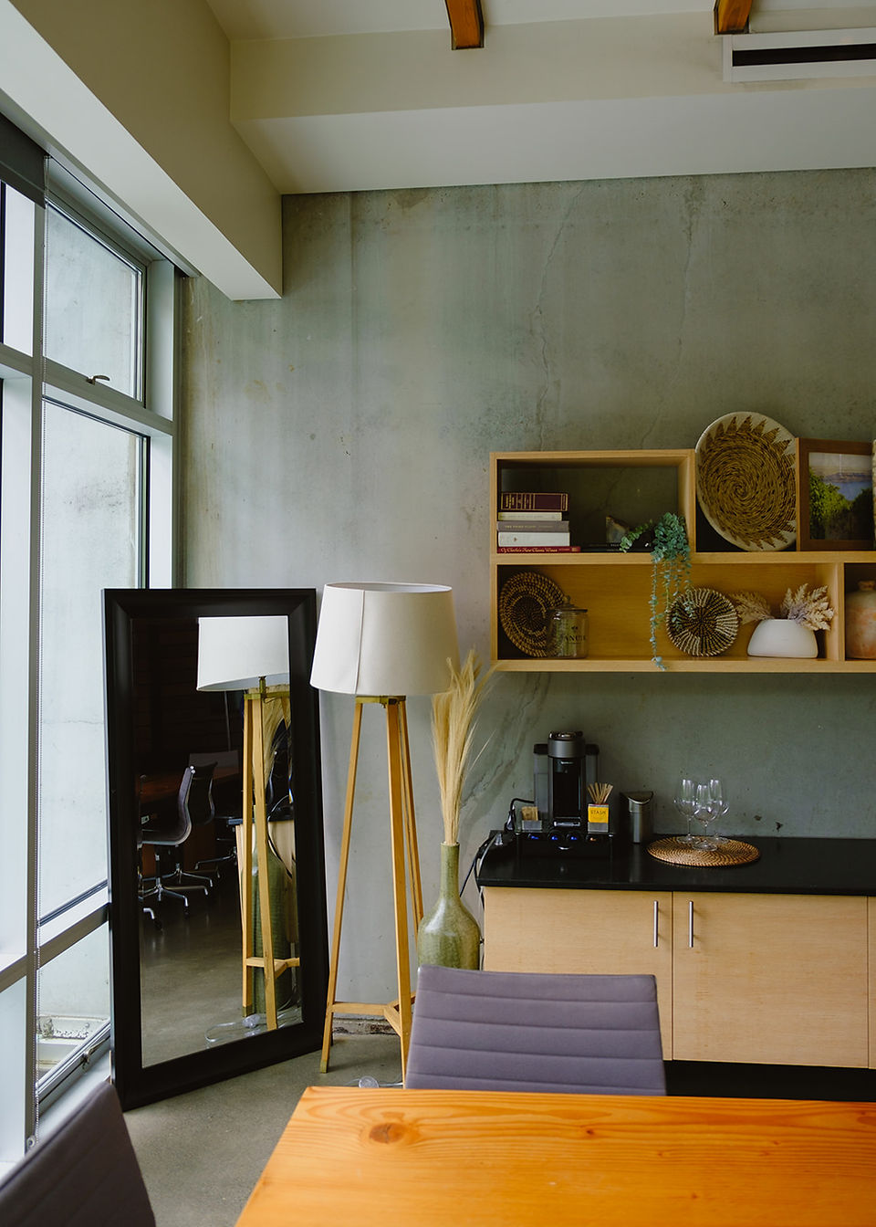 indoor getting ready space with bookshelf, coffee maker and large mirror