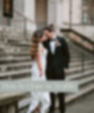 How to elope in seattle: man in black suite holding women in white wedding dress on stone steps
