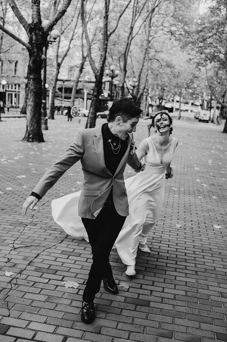 wedding couple holding hands looking at each other walking down brick alley way