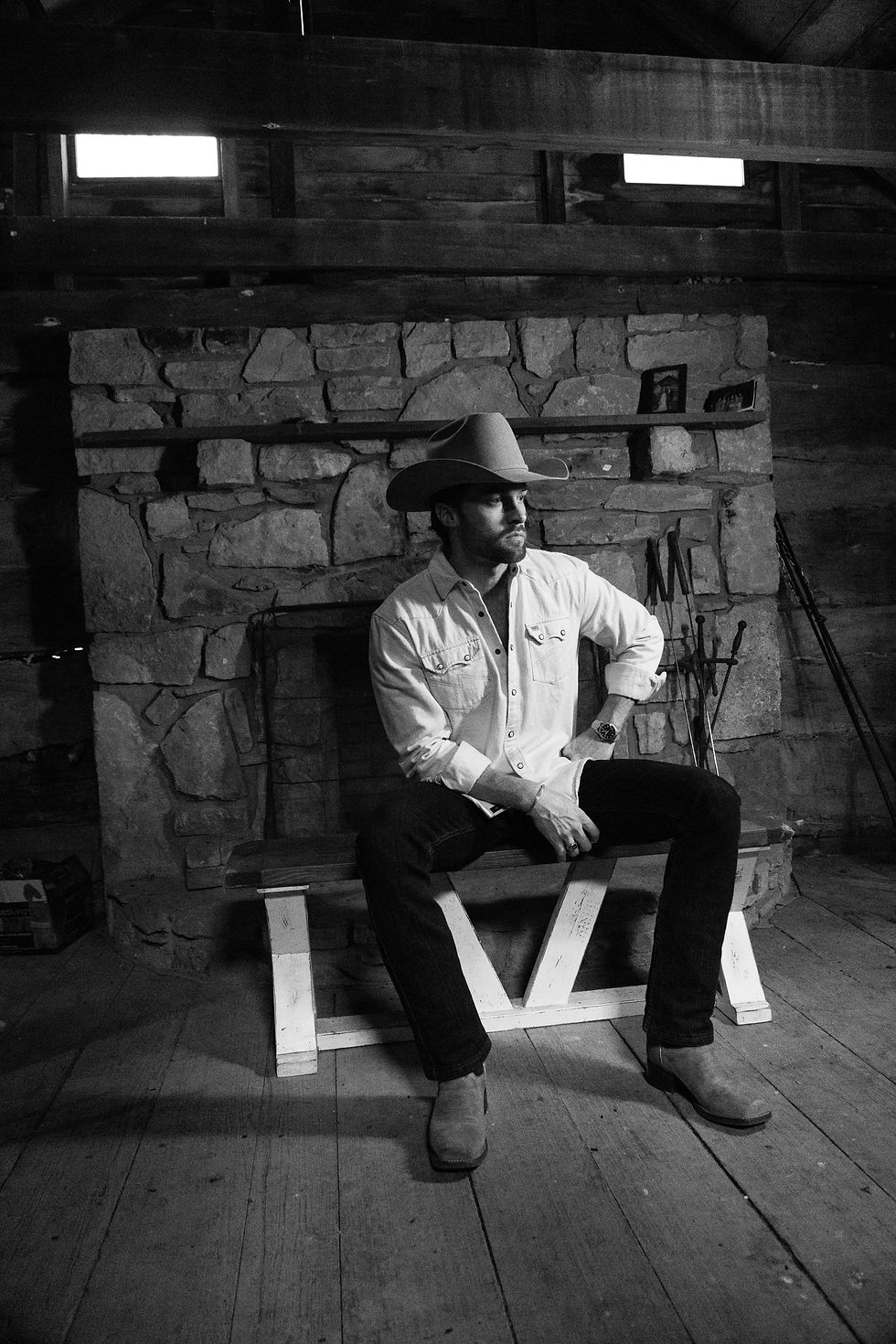 Country music artist poses for album cover photo in front of fireplace.