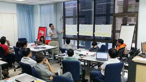 Micron team leader presenting current state value stream map analysis to team members during an OEC-facilitated VSM workshop in Singapore