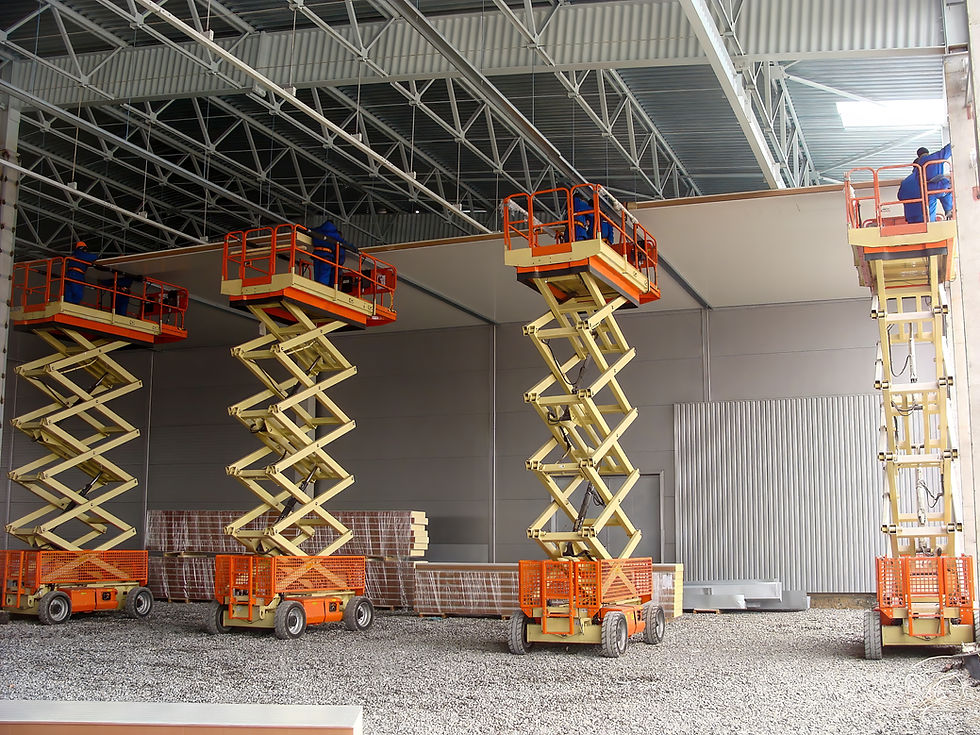 Workers installing PIR sandwich panels using scissor lifts inside a warehouse.jpg