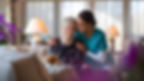 smiling caregiver with elderly patient home thehomecareaid
