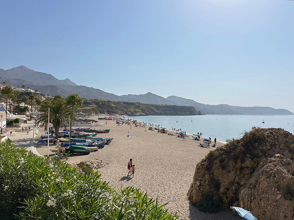 Fishing boats, people and mountains at Burriana Beach in Nerja