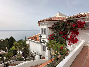 Casa blanca en Punta Lara con vistas al mar, flores y cielo azul