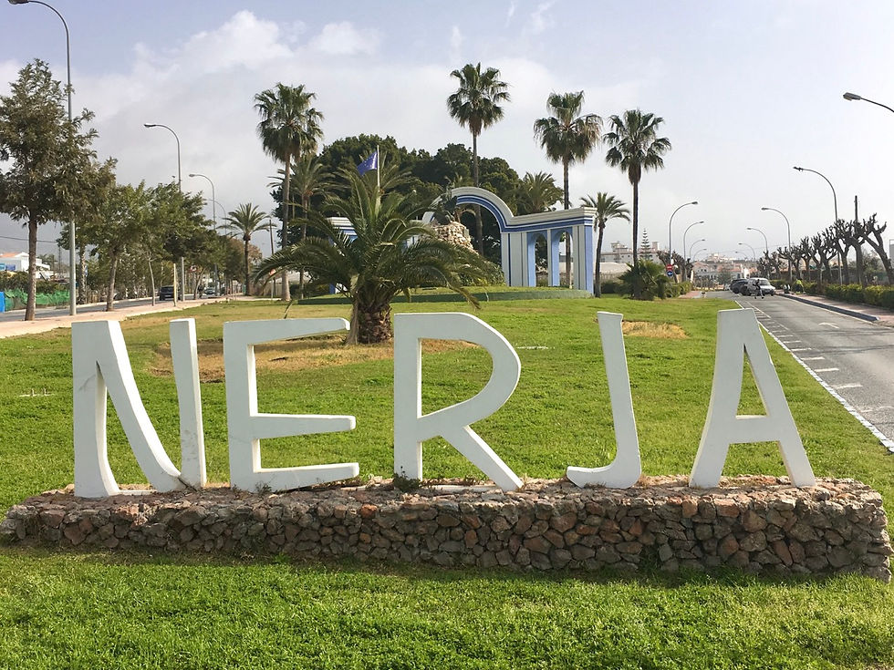 Patsas, jossa lukee "Nerja" suurin kirjaimin, taustalla upea maisema.