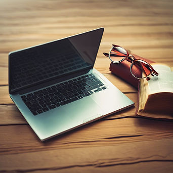 a laptop computer and a bible with a pair of glasses.jpg