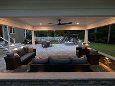 Backyard cabana with lighting and a ceiling fan on a paver patio.