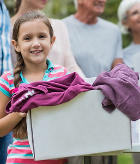 Photograph of a child carrying a box of donated clothes