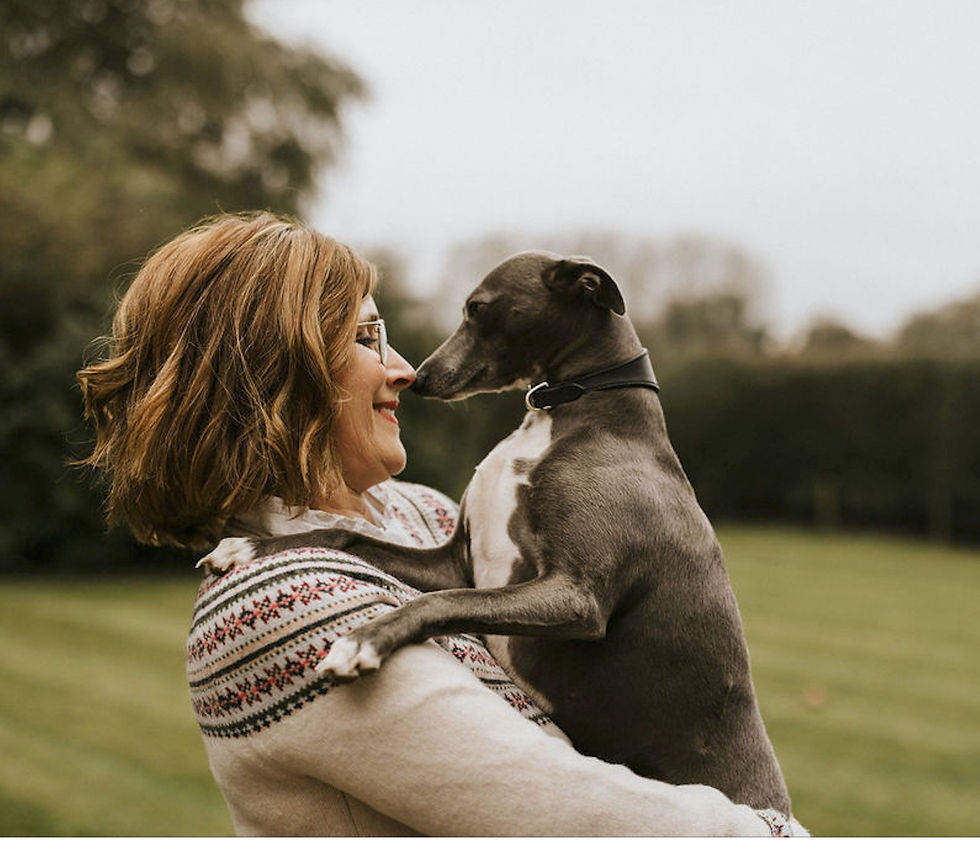 a whippet in Jane Haigh's arms smiling