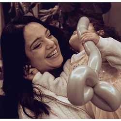 mother laughing while holding her daughter