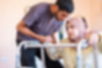 muslim woman with disability is trying to stand with her son's help