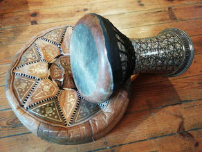 Darbouka drum placed on a cushion on a wooden floor
