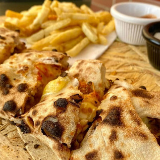 Baguette farcie pieces served with fries, showing melted cheese and filling