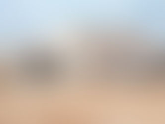 Limewashed domed structure with matte mineral surface exposed to wind and dust in Tunisia