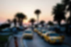 Yellow taxis lined up along a coastal road in Tunisia at sunset