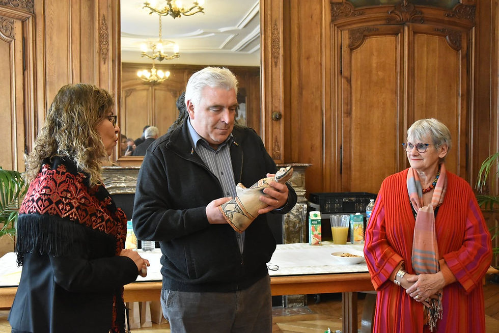 Man examining a Sejnane pottery vessel during a cultural reception in Boulogne-sur-Mer.