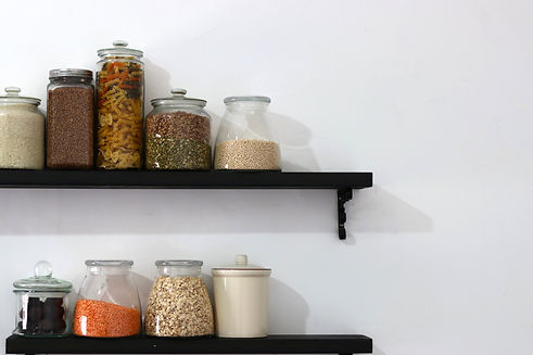Pantry shelves with jars of grains, pasta, and legumes arranged for daily use