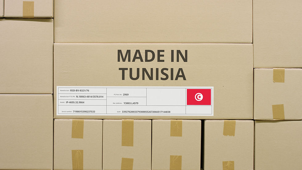 Empilement de cartons neutres marqués « Made in Tunisia » avec étiquette logistique et drapeau tunisien — symbole d’un savoir-faire exporté sans folklore.