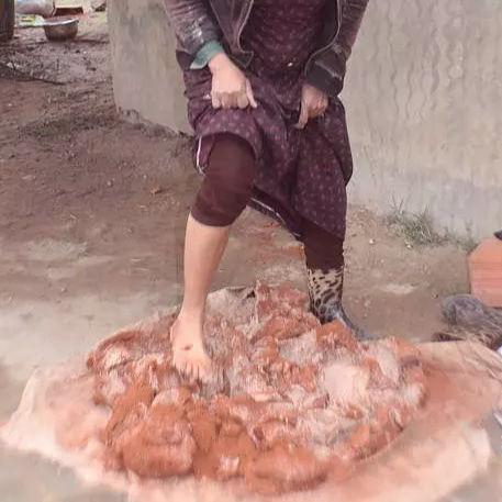 Sejnane potter kneading wet clay with her foot during preparation.