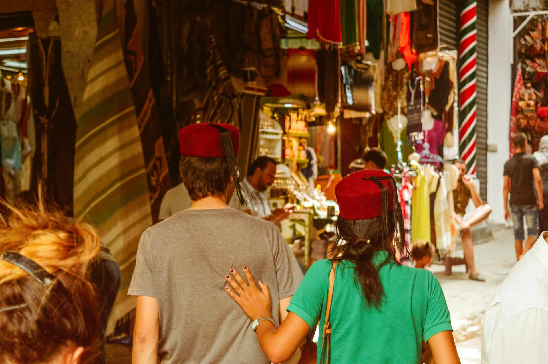 Visitors walking through a busy market street in a Tunisian medina